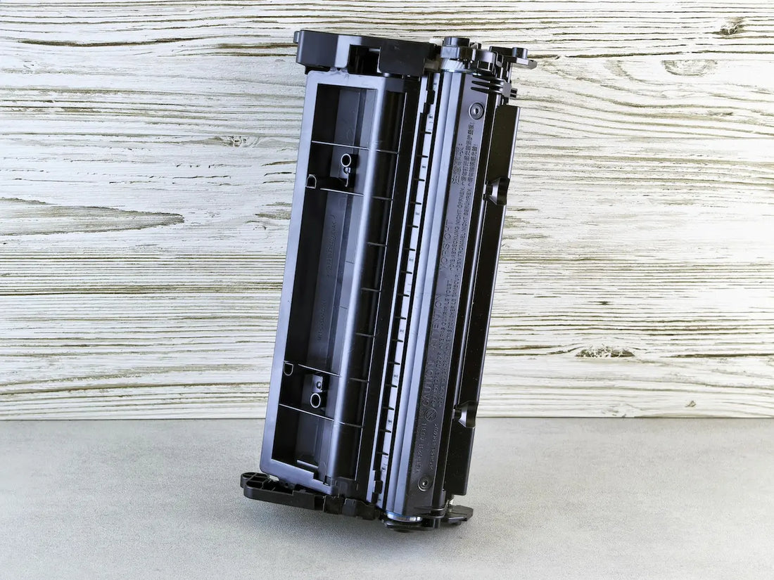 Black toner cartridge sitting on wooden background