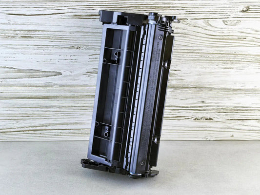 Black toner cartridge sitting on wooden background